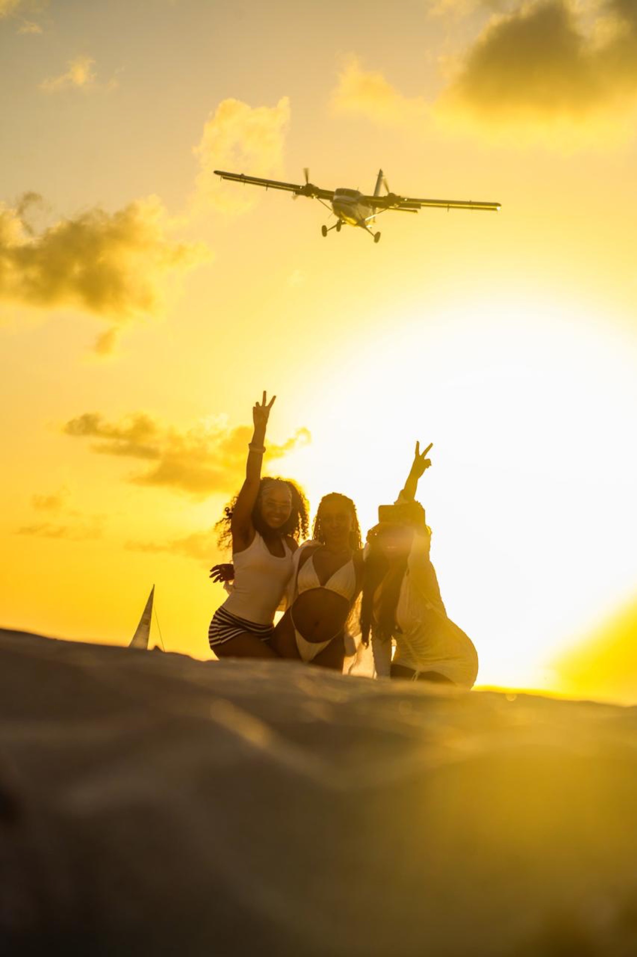 Golden-hour sunset on a Sint Maarten beach with a plane overhead